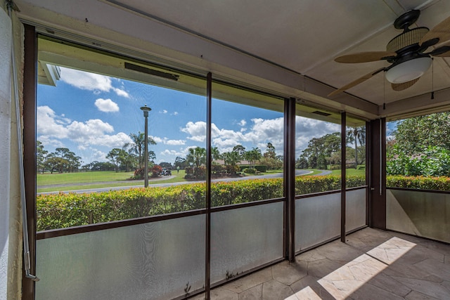 unfurnished sunroom with ceiling fan