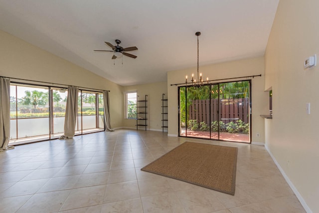 spare room featuring lofted ceiling, ceiling fan with notable chandelier, and light tile flooring