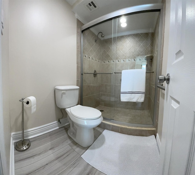 bathroom featuring toilet, walk in shower, and ornamental molding