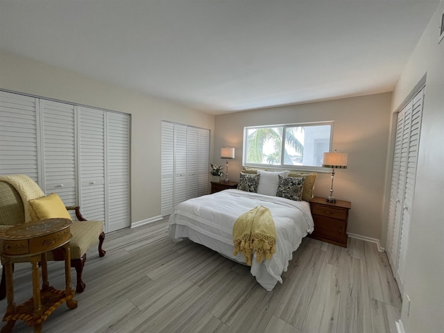 bedroom with light hardwood / wood-style flooring and two closets