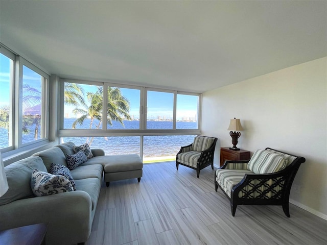 sunroom featuring a water view