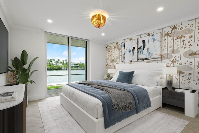 bedroom with access to outside, crown molding, a water view, and expansive windows