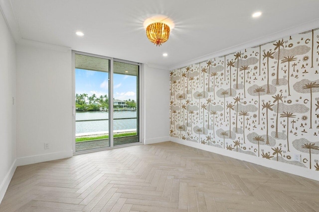 empty room with crown molding, light parquet floors, a wall of windows, and a water view