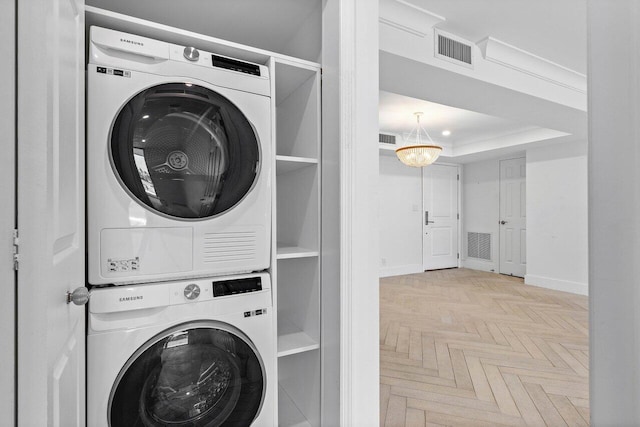 washroom featuring stacked washer / dryer and light parquet floors