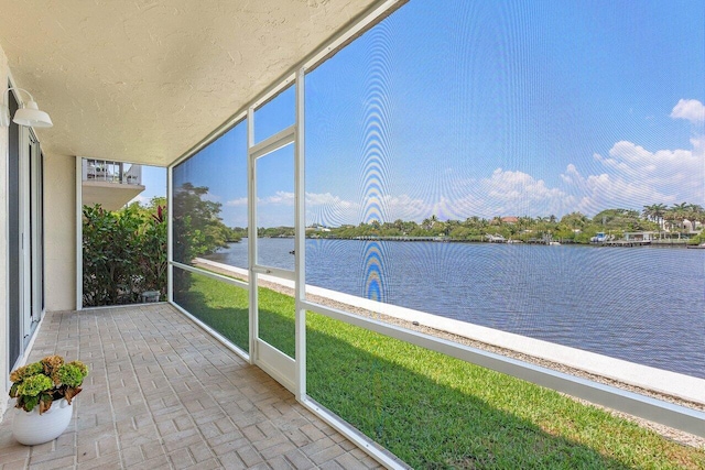 unfurnished sunroom with a water view