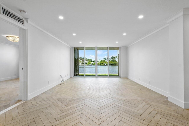 empty room featuring light parquet floors, ornamental molding, and a water view