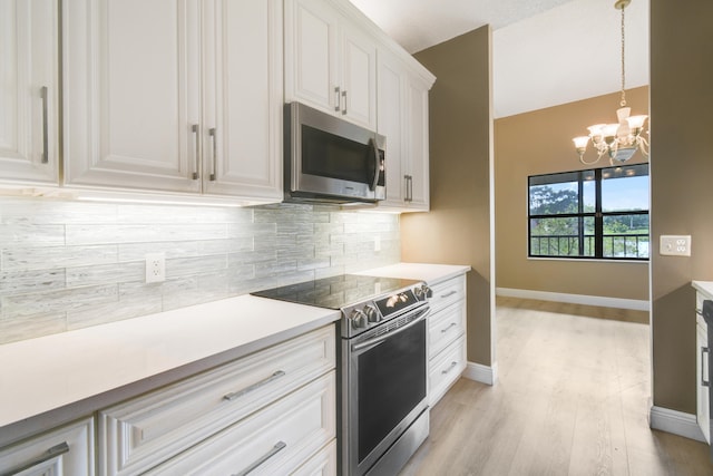 kitchen featuring a notable chandelier, decorative backsplash, appliances with stainless steel finishes, decorative light fixtures, and white cabinetry