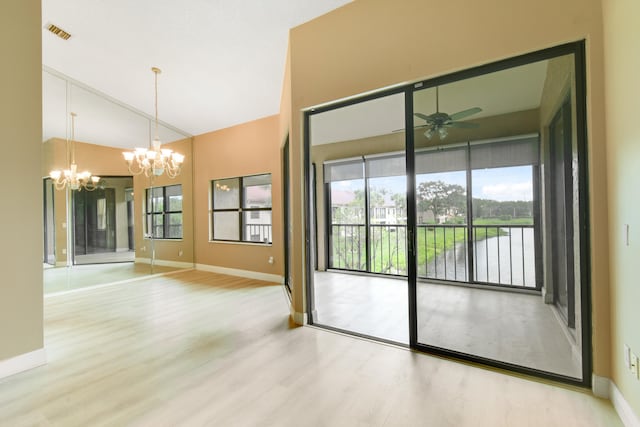 interior space with ceiling fan with notable chandelier, hardwood / wood-style flooring, and a healthy amount of sunlight