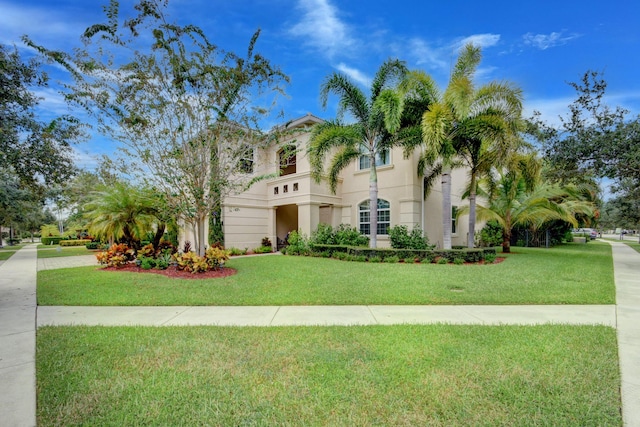 mediterranean / spanish house with a front lawn and stucco siding