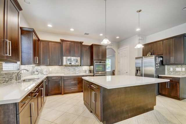 kitchen with sink, decorative light fixtures, stainless steel appliances, a center island, and decorative backsplash