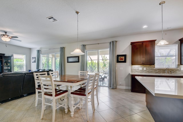 dining room with ceiling fan, plenty of natural light, light tile patterned flooring, and a textured ceiling