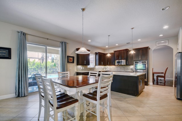 tiled dining room with a textured ceiling