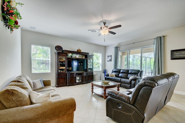 living room with a healthy amount of sunlight, light tile patterned floors, and ceiling fan