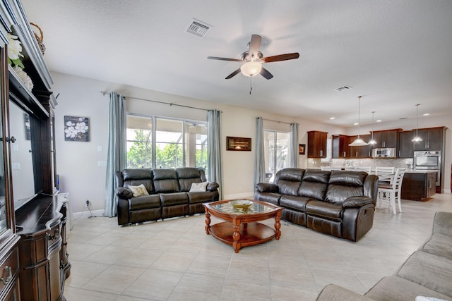 tiled living room featuring ceiling fan