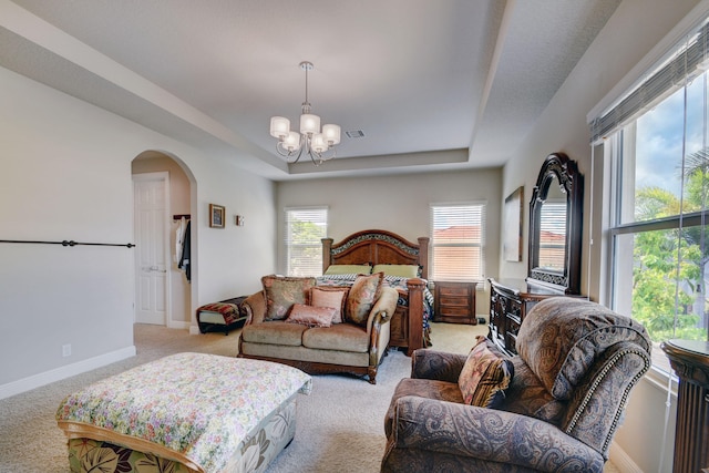 carpeted living room featuring a raised ceiling and a chandelier