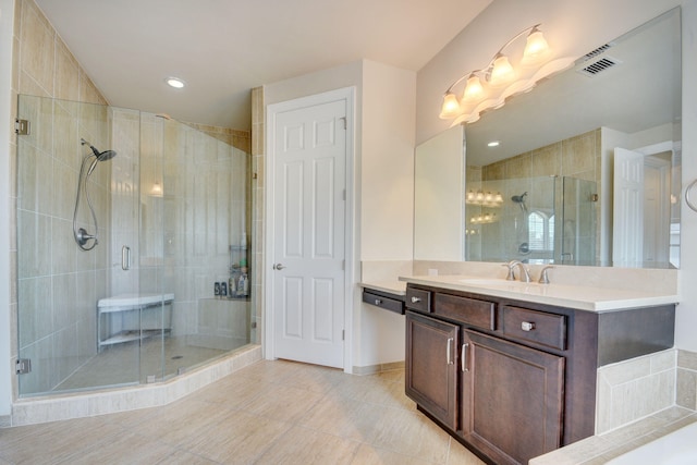 bathroom featuring tile patterned flooring, a shower with door, and vanity