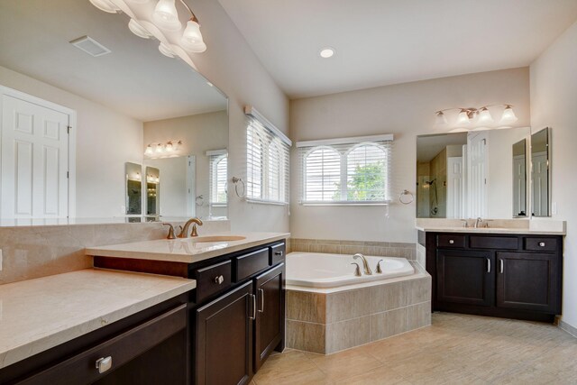 bathroom featuring tile patterned flooring, vanity, and plus walk in shower