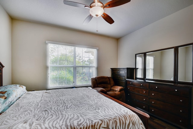 bedroom with dark hardwood / wood-style flooring and ceiling fan