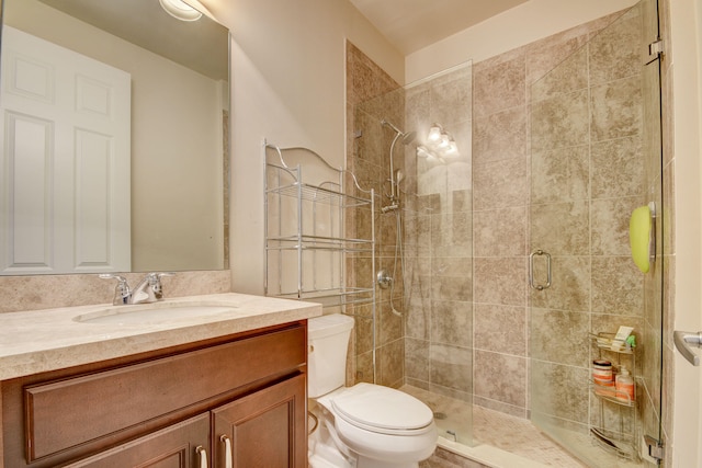 bathroom with walk in shower, vanity, and toilet