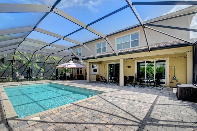 view of pool with ceiling fan, a lanai, and a patio area