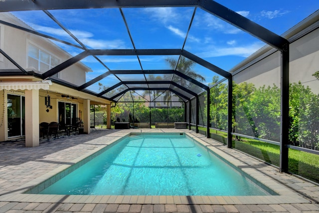 view of swimming pool featuring a patio, ceiling fan, and glass enclosure