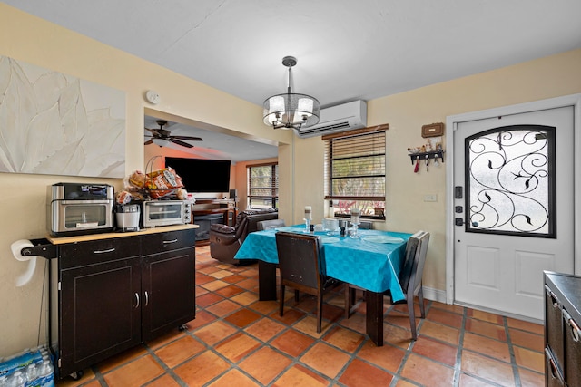 tiled dining space featuring an AC wall unit and ceiling fan with notable chandelier