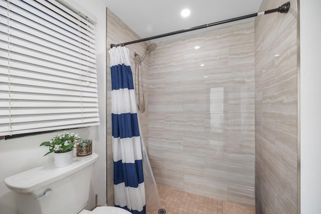 bathroom featuring a shower with shower curtain and toilet