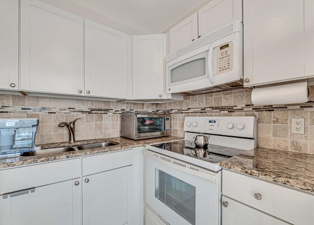 kitchen with sink, white appliances, tasteful backsplash, and white cabinetry