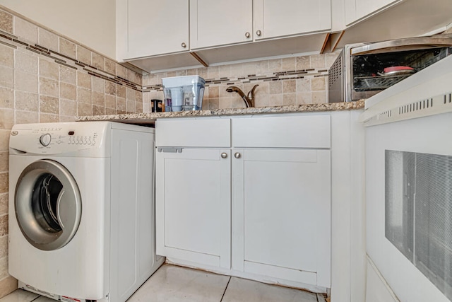 laundry area with washer / dryer, cabinets, and light tile floors