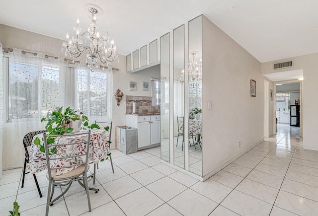 tiled dining space with an inviting chandelier