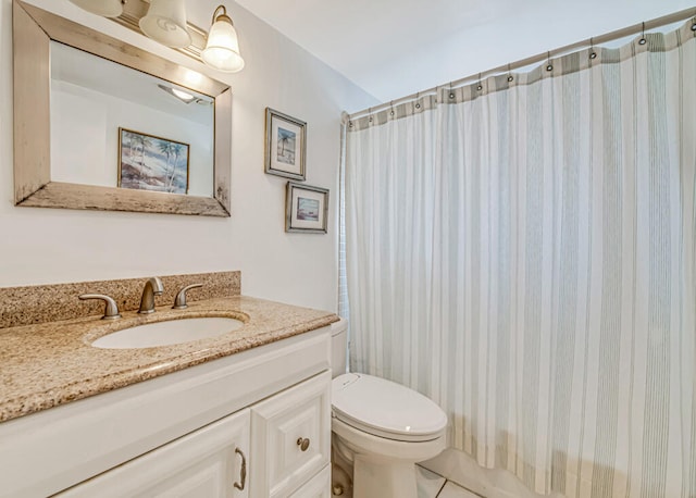 bathroom with toilet, vanity with extensive cabinet space, and tile flooring