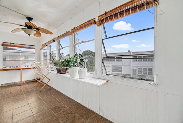 unfurnished sunroom with ceiling fan