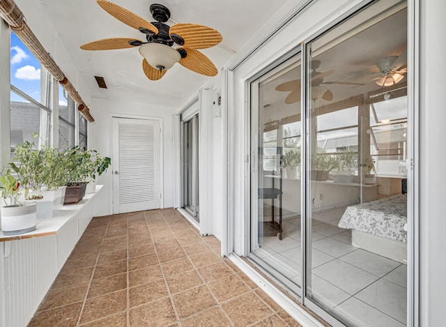 unfurnished sunroom featuring ceiling fan