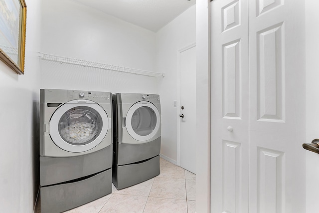 laundry area with light tile patterned flooring and independent washer and dryer