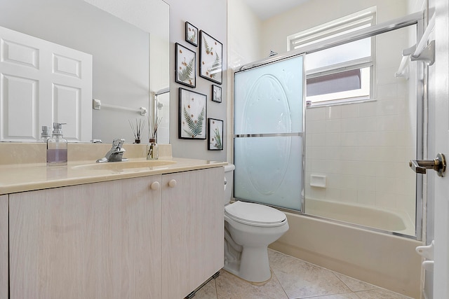 full bathroom featuring tile patterned floors, vanity, combined bath / shower with glass door, and toilet