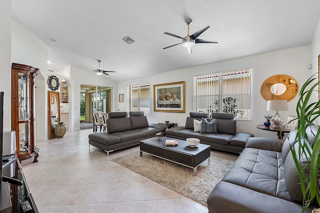 tiled living room with a textured ceiling, ceiling fan, and vaulted ceiling