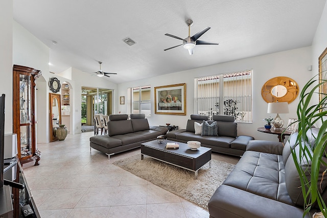 living room with a textured ceiling, ceiling fan, lofted ceiling, and light tile patterned floors