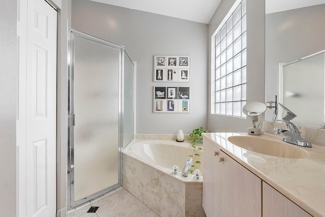 bathroom featuring plus walk in shower, vanity, and tile patterned flooring