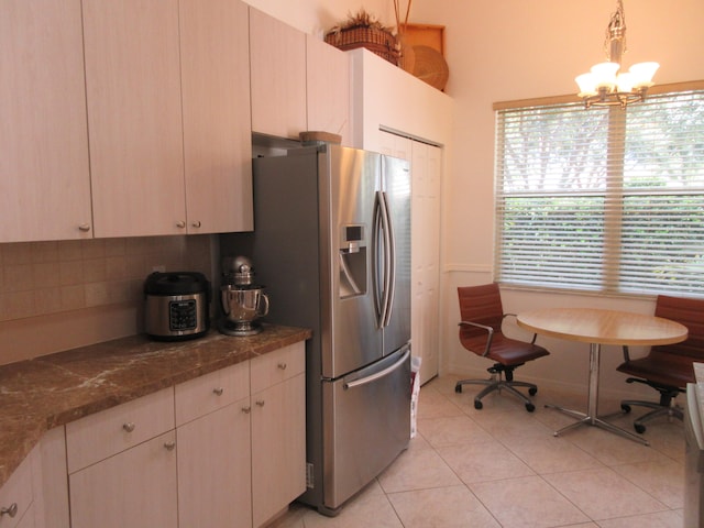 kitchen featuring a notable chandelier, light tile patterned flooring, tasteful backsplash, pendant lighting, and stainless steel fridge