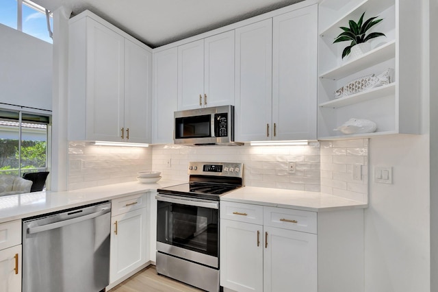 kitchen with a healthy amount of sunlight, stainless steel appliances, and white cabinets