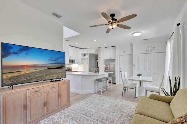 living room featuring sink, light hardwood / wood-style floors, crown molding, and ceiling fan