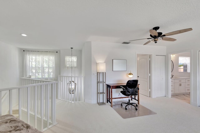 carpeted office with ceiling fan and a healthy amount of sunlight