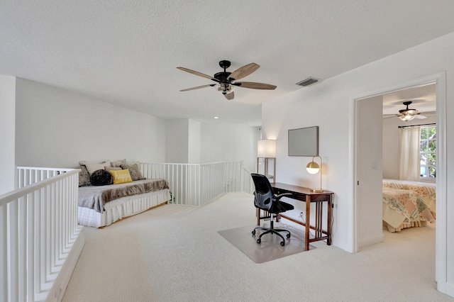 home office featuring a textured ceiling, ceiling fan, and carpet flooring