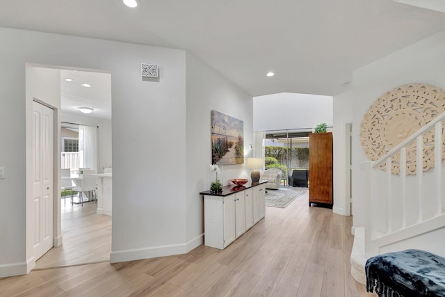 hall with plenty of natural light and light hardwood / wood-style flooring