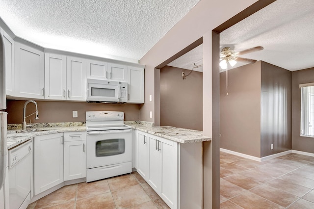 kitchen featuring light stone counters, ceiling fan, light tile floors, sink, and white appliances