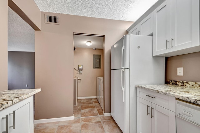 kitchen featuring separate washer and dryer, white appliances, light tile floors, and light stone countertops