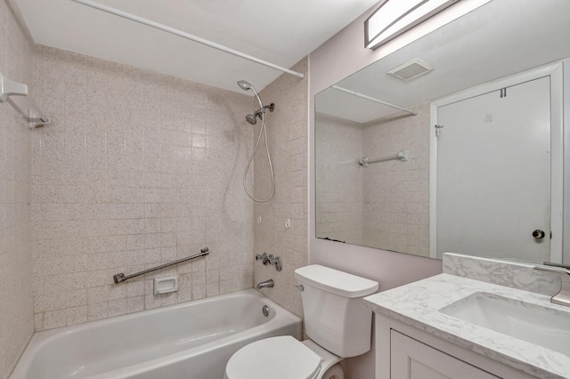 full bathroom featuring tiled shower / bath combo, vanity, and toilet