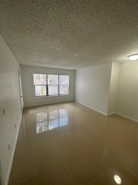 empty room featuring tile flooring and a textured ceiling