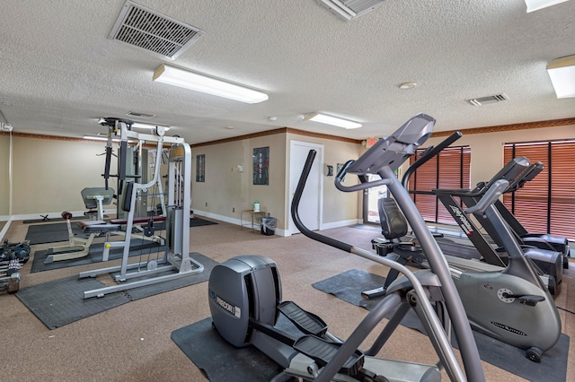 exercise room featuring a textured ceiling, carpet floors, and ornamental molding