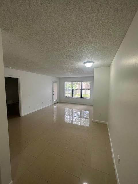 spare room with tile flooring and a textured ceiling